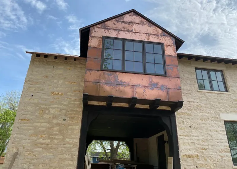 Copper metal panel facade on a stone building for Roof Repair in Port Neches